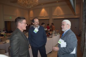 Three Men Talking to Each Other in a Room