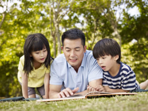 A Father Lying on Grass With Kids