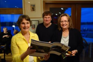 Two Women and a Man Holding a Book