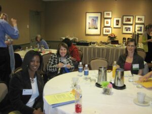 A Group of Women in Formals Sitting by a Table