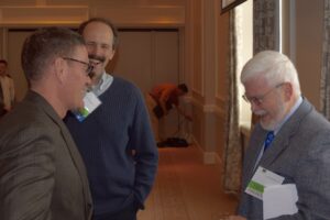 Three Men Laughing at Each Other in a Room