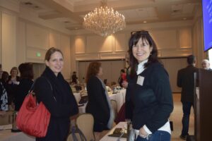 Two Women Smiling and Looking at a Camera