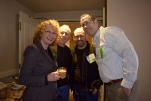 A Woman Holding a Glass of Tea With Three Men