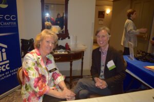 Two Women Sitting Cross Legged on Chairs