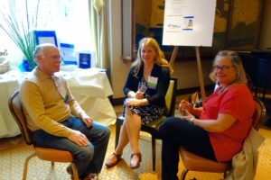 Two Women and a Man Sitting on Chairs