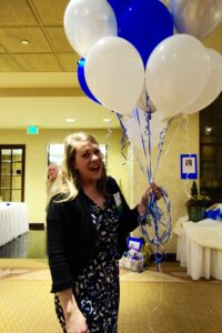 A Woman Holding a Bunch of Blue and White Balloons