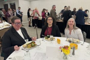 Three people enjoying their lunch at the conference.