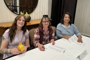 Three volunteers selling raffle tickets